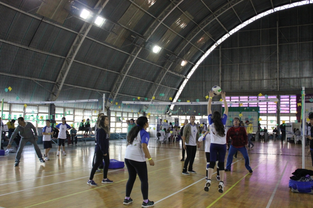 Alunos se divertem ao jogarem voleibol com seus familiares.